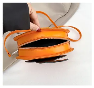 Macro view of orange pumpkin bag showing metal zipper closure and black fabric lining interior