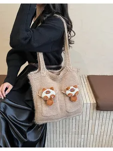 Dettaglio della trama a maglia e dei decori a gatto in peluche 3D sulla borsa