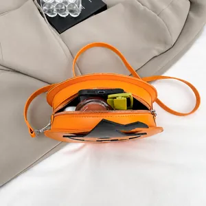 Macro shot showing internal capacity and zipper detail of the orange pumpkin crossbody bag