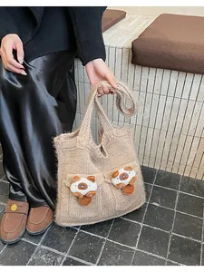 Dettaglio della borsa in maglia con gatti in peluche e trama all'uncinetto color kaki