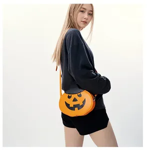Detail of pumpkin crossbody bag with wizard hat and orange strap on model