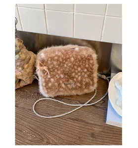 Détail du sac en peluche à motif cerf avec bandoulière en strass et breloque cerf