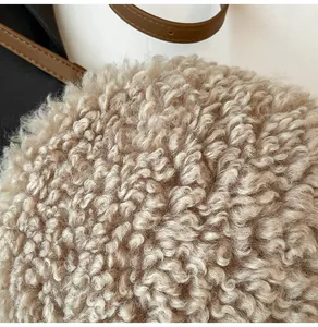 Gros plan sur la texture laine d'agneau beige et la bandoulière en cuir du sac rond
