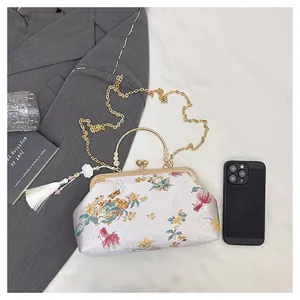 Detailed embroidery of goldfish and floral patterns on silk shell-shaped evening bag