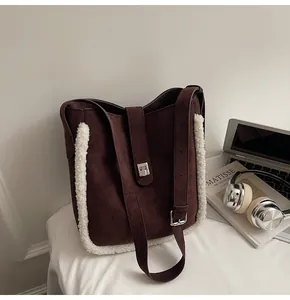 Detail der braunen Wildleder-Schultertasche mit weißem Fleece-Besatz und silberner Schnalle