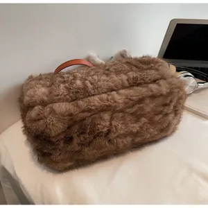 Gros plan sur la texture en fausse fourrure marron et la poignée en cuir d'un sac à bandoulière