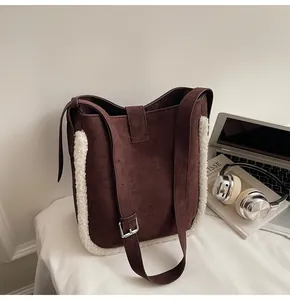 Detail der dunkelbraunen Wildleder-Schultertasche mit Lammfell-Besatz und Trageriemen