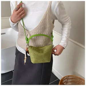 Detail der grünen Wildleder-Einkaufstasche mit Perlenanhänger und verstellbarem Riemen
