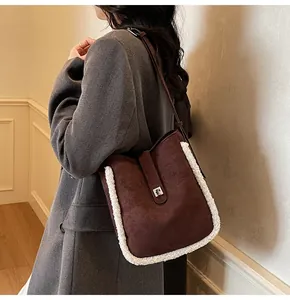 Detail der braunen Wildleder-Schultertasche mit weißem Lammfell-Besatz und Metallschließe