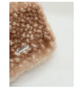 Gros plan sur la texture fausse fourrure motif cerf avec logo en métal rectangle