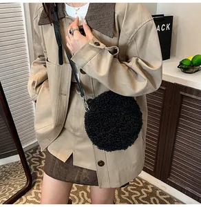 Détail du sac à bandoulière rond en peluche noire douce avec fine sangle réglable