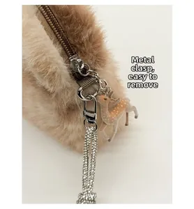 Détail de la boucle métallique et du pendentif cerf sur un sac en peluche marron