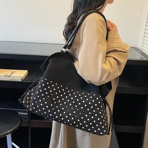 Modische Tote Bag mit Polka Dots und Stickerei auf der Schulter eines Models gezeigt