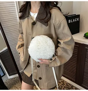 Détail d'un sac à bandoulière rond en fausse fourrure blanche avec un manteau kaki