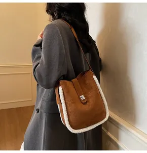Detail der Vintage-Wildledertasche mit Lammfellbesatz auf einem grauen Wollmantel