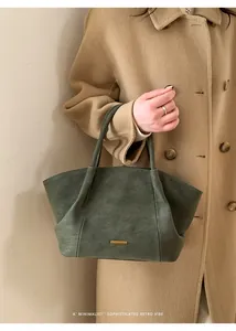 Detailed view of dark green retro tote bag featuring a sleek gold metal buckle detail