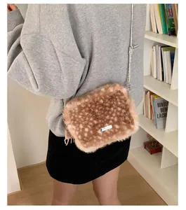 Détail du sac en peluche à motif cerf avec chaîne argentée et breloque cerf assortie