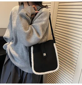 Detailansicht der schwarzen Wildledertasche mit weißem Lammfellbesatz und silberner Schnalle