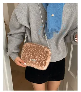 Détail d'un sac en peluche à motif cerf avec bandoulière chaîne et logo en métal