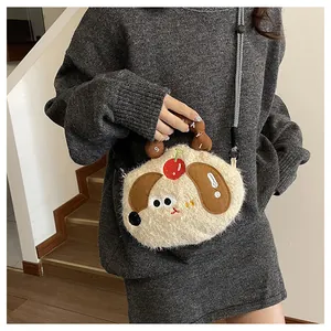 Detail of plush puppy bag featuring a red cherry accent and Sayi embroidered handle