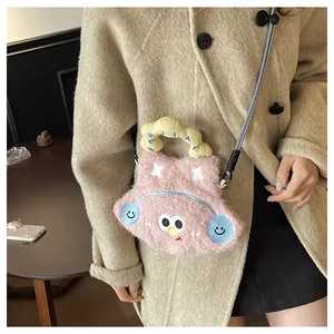 Detail of pink plush crossbody bag with cartoon monster face and yellow handle