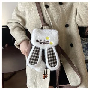 Détail du sac à dos lapin en peluche avec oreilles à carreaux et écusson brodé
