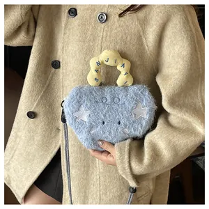 Detail of light blue plush bag with white star patch and yellow wavy handle embroidery