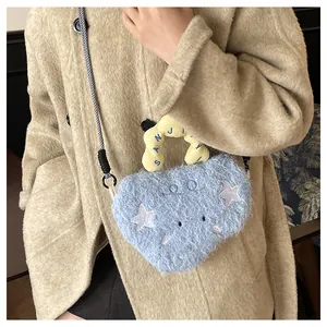 Detail of blue plush heart bag featuring white star patch and yellow pleated handle strap