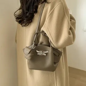 Women's dark khaki lychee leather handbag with silver bow buckle and mini pendant