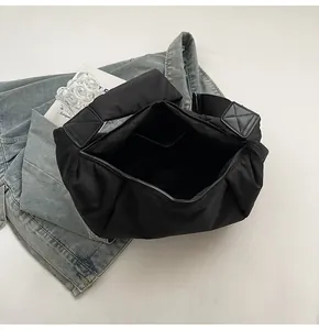 Vue de dessus d'un grand sac hobo en nylon noir avec fermeture et bandoulière