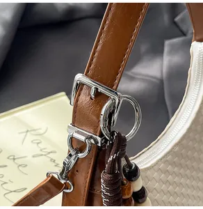 Detailed macro view of woven beige fabric with brown leather strap and silver hardware