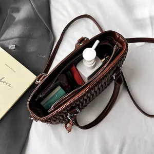 Top view of deep brown tote bag showing internal capacity with lipstick and small wallet