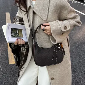 Deep brown Hobo shoulder bag with woven texture and artistic bead charm in street setting
