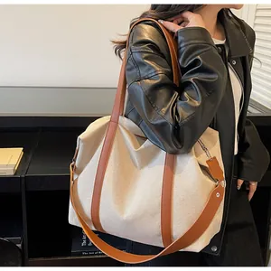 Detail of canvas tote bag with leather straps and adjustable shoulder strap for women