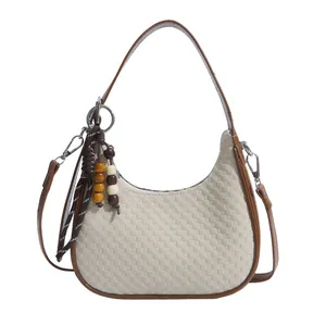 Beige woven hobo handbag with brown leather straps and wooden bead charm accent