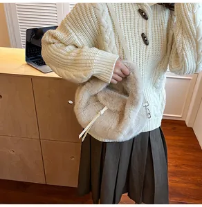 Détail du sac à main en peluche avec gland en cuir blanc et fine bandoulière