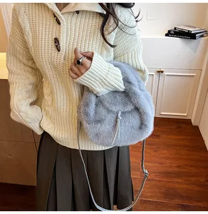 Vue détaillée d'un sac à bandoulière en peluche bleu clair avec cordon et sangle en cuir