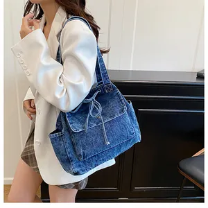Detalle de bolso tote denim vintage con lazo decorativo y textura del bolsillo lateral