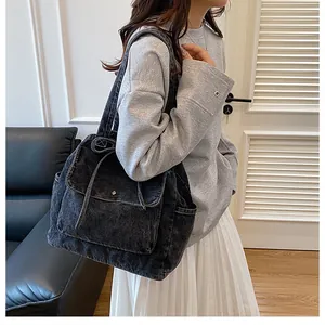 Primer plano del bolso tote de mezclilla negra retro con bolsillos y correas resistentes