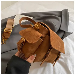 Detail of vintage brown suede messenger bag with multi-pockets and wide strap