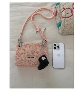 Détail du sac à bandoulière en laine d'agneau rose avec sangle en corde contrastée et charms