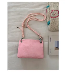 Détail du sac à bandoulière rose en peluche avec sa bandoulière unique en corde nouée