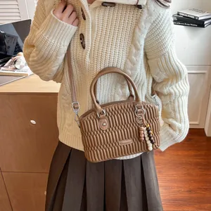 Bolso de mano en piel acolchada marrón con adorno de cuentas de madera y bandolera