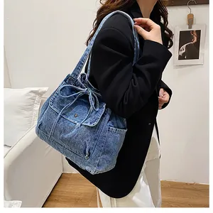 Detalles del bolso tote de mezclilla azul con cordón de lazo y bolsillo lateral