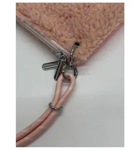Détail du sac en polaire rose avec fermeture éclair argentée et poignée tissée