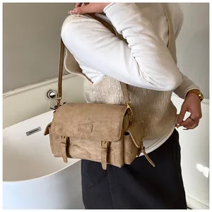Retro khaki frosted messenger bag featuring double buckles and side flap pockets on model