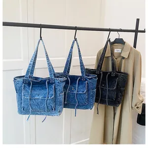 Detalle de los bolsos tote de mezclilla retro azul y negro con cordón y bolsillo con solapa