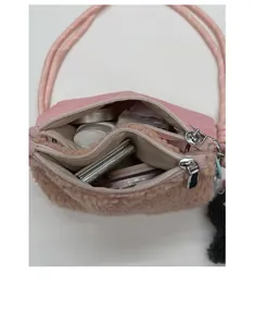 Compartiments internes du sac bandoulière rose en polaire pour ranger le maquillage