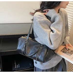 Détail du sac à bandoulière noir vintage avec texture effet cuir et zips décoratifs