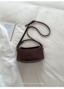Détail d'un sac à bandoulière en daim marron foncé avec quincaillerie dorée rétro élégant